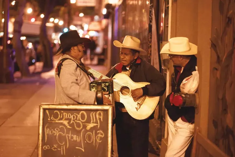 Three Mexican musicians perform on a street in the 任务地区 of San Francisco.